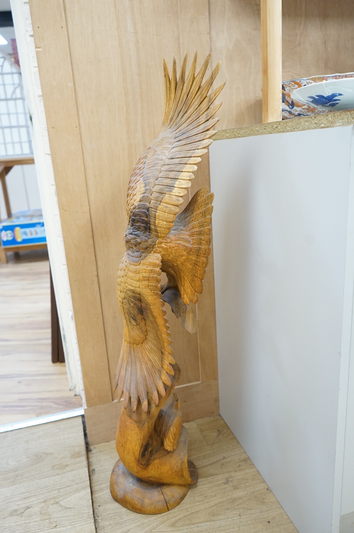 A large carved wood sculpture of an eagle and prey, 102cm high